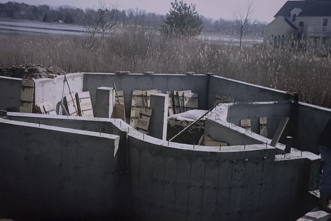 Finished foundation with a curved wall, with marsh and water behind it