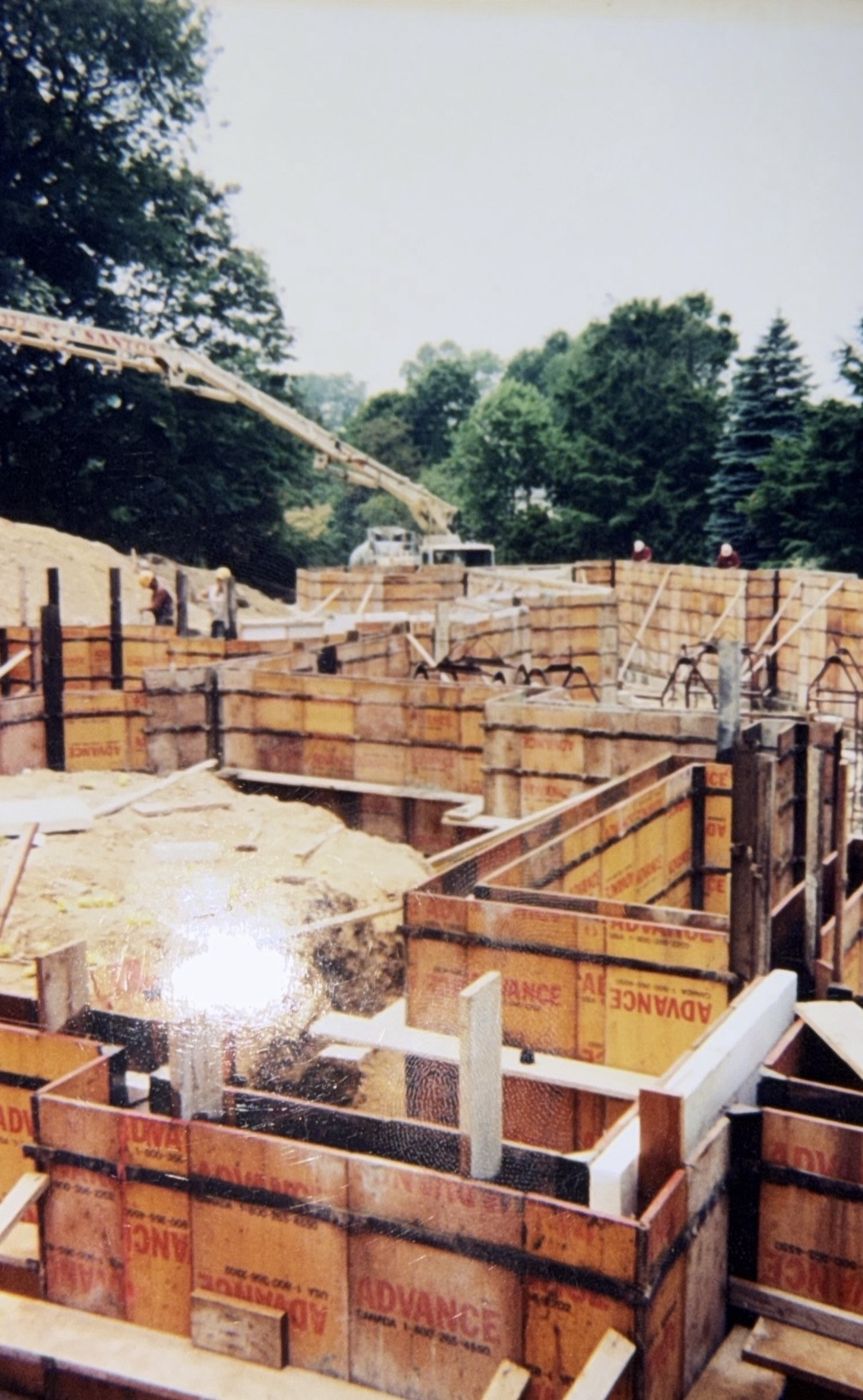 Older photo of wall forms with a pump truck boom overhead