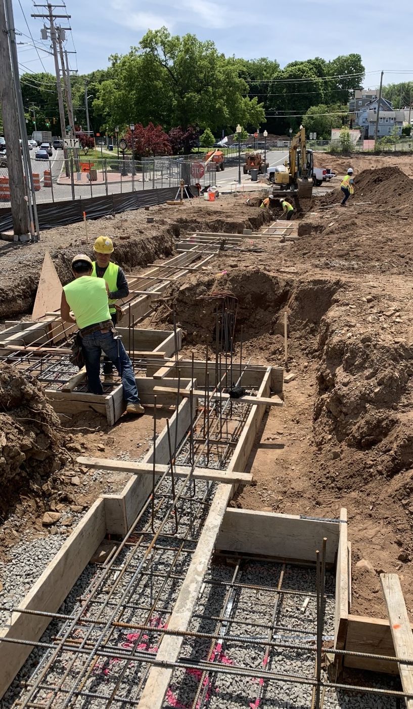 Crew forming footings with rebar along a street