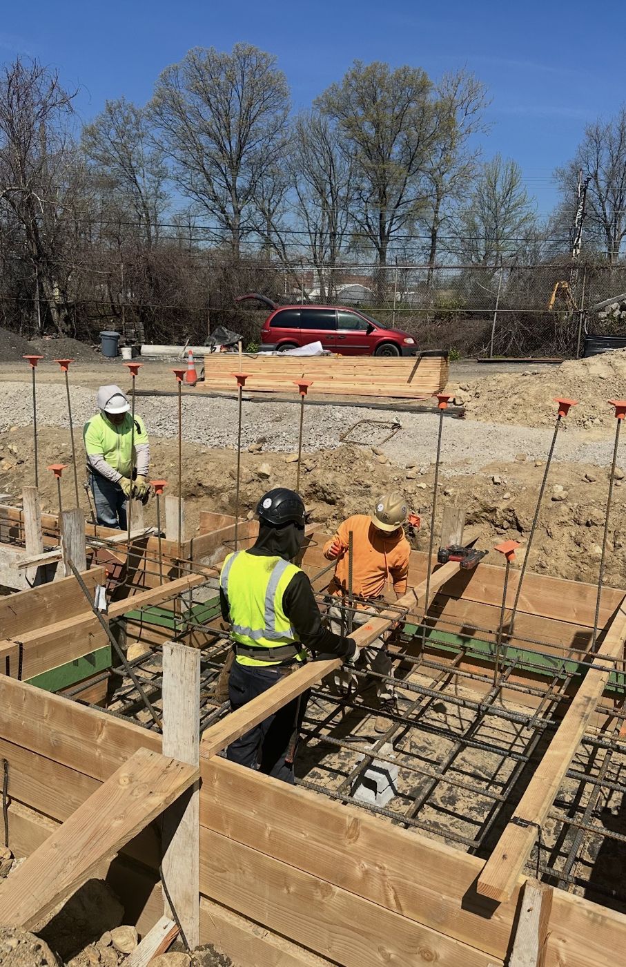 Crew tying rebar inside a formed footing