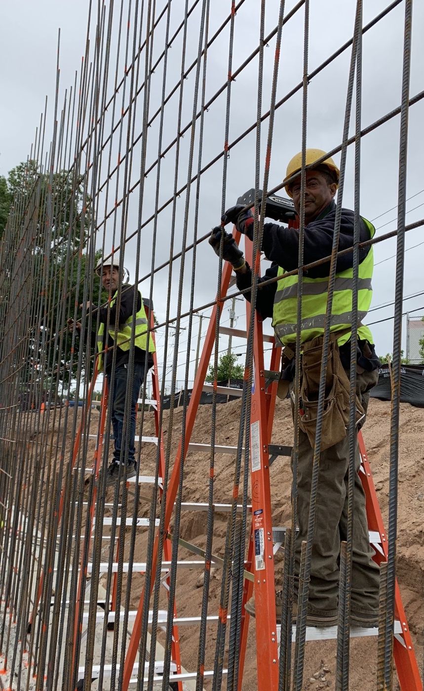 Crew tying a tall rebar wall mat